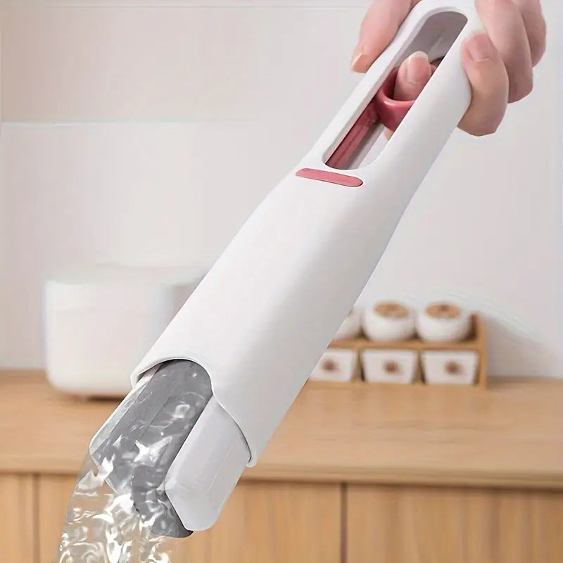 White kitchen tool with water being poured from it, set against a neutral background.