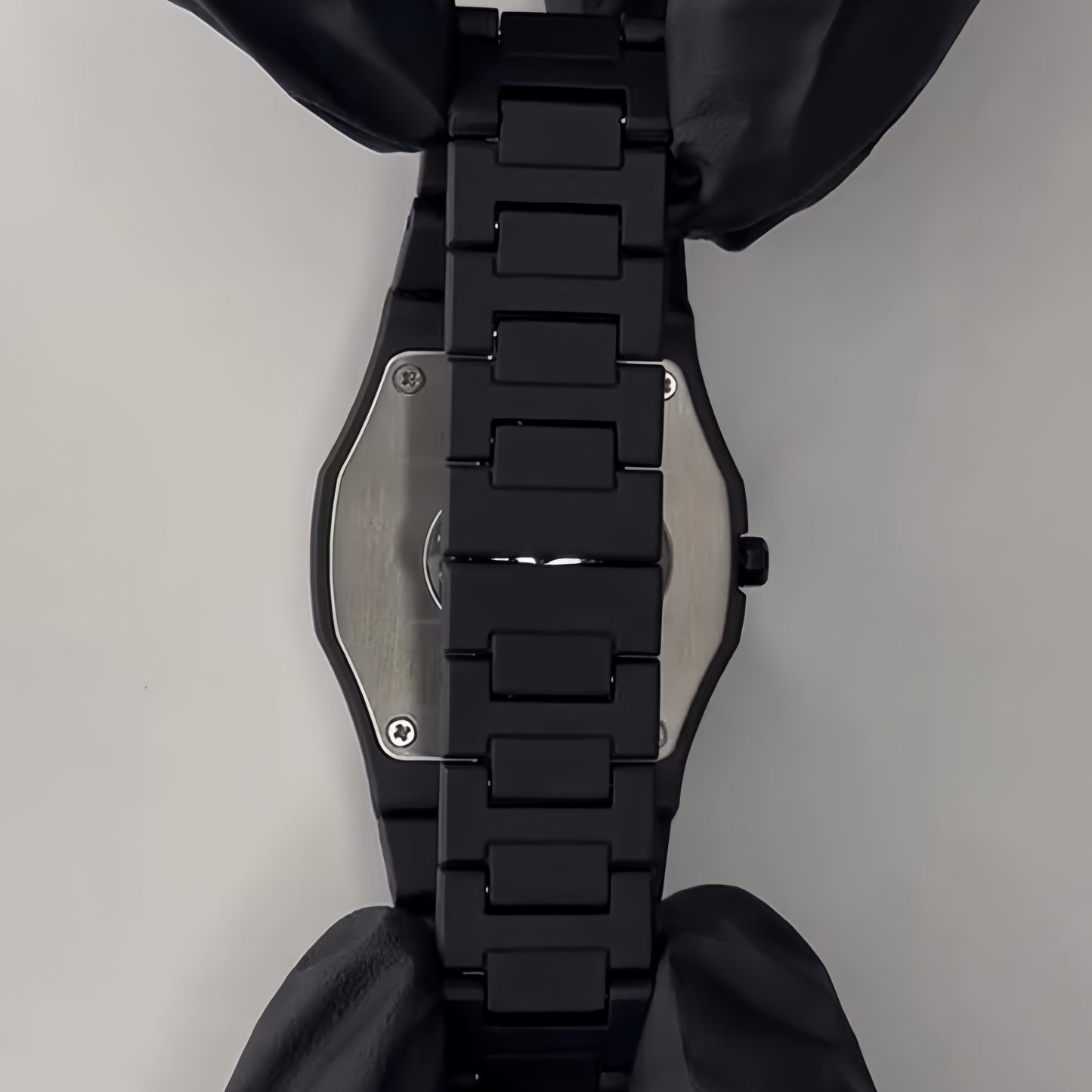 Black dog harness with metallic buckle on a gray background