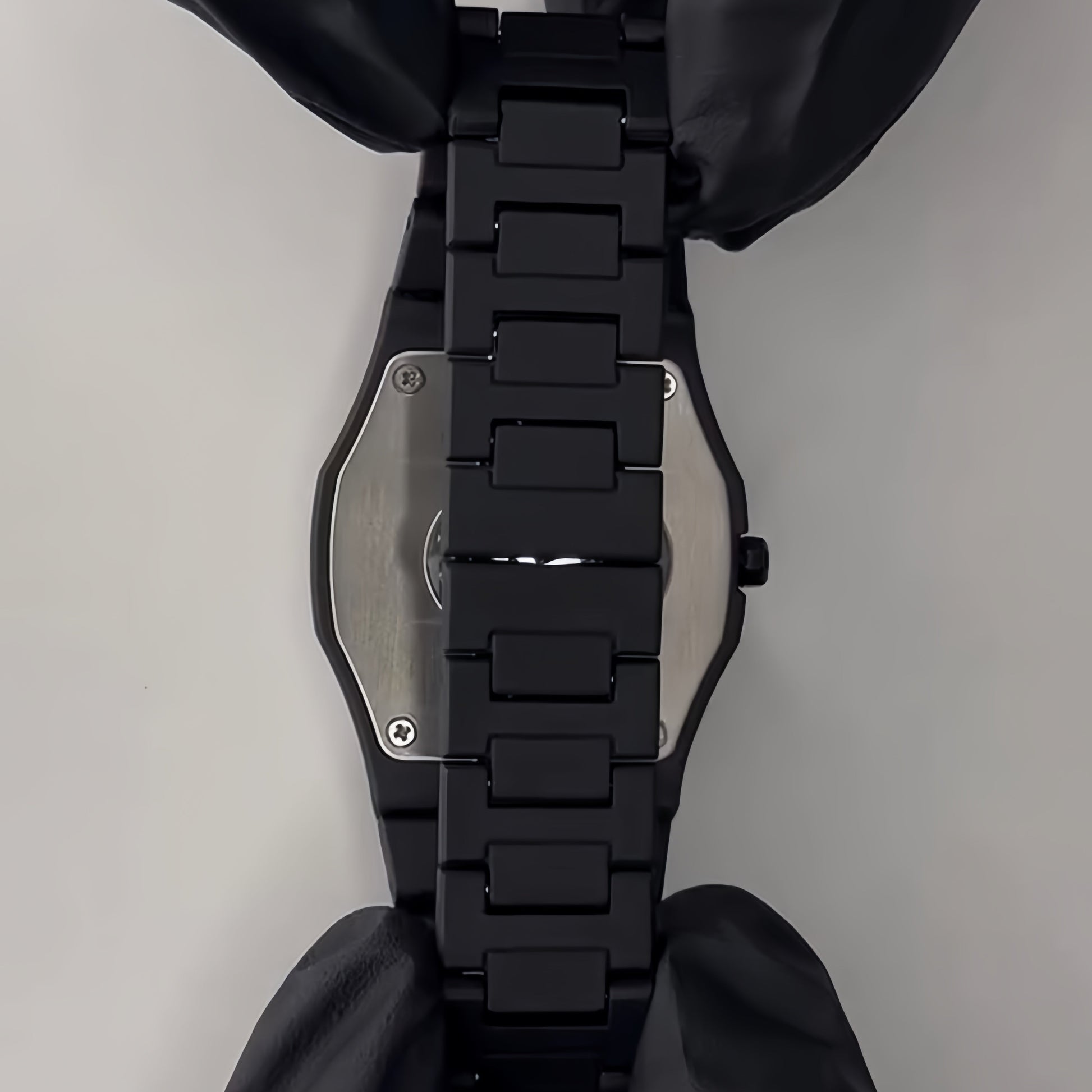 Black dog harness with metallic buckle on a gray background