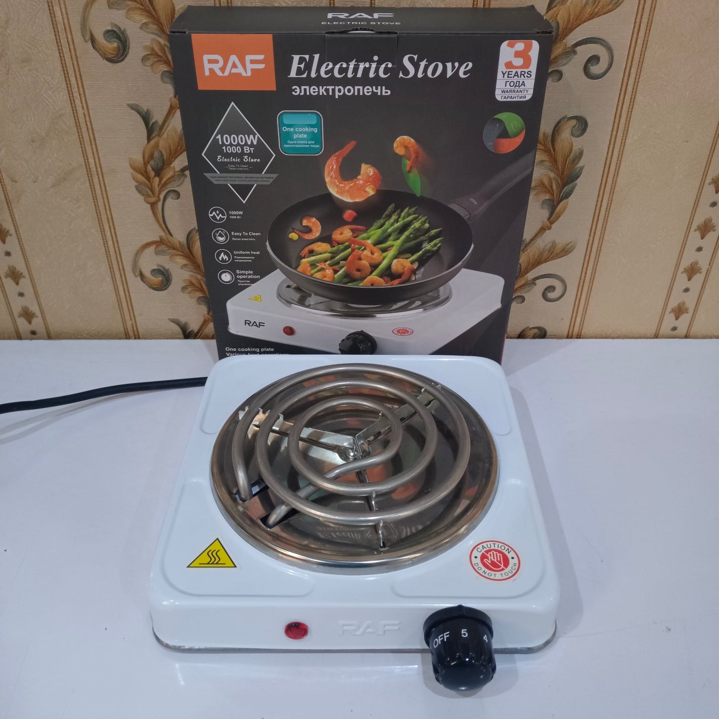 RAF electric stove on a white surface with packaging in the background