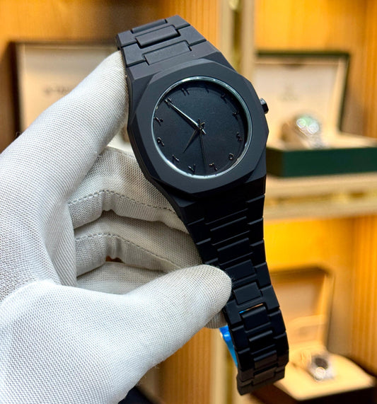 Black watch held by a gloved hand with a blurred background