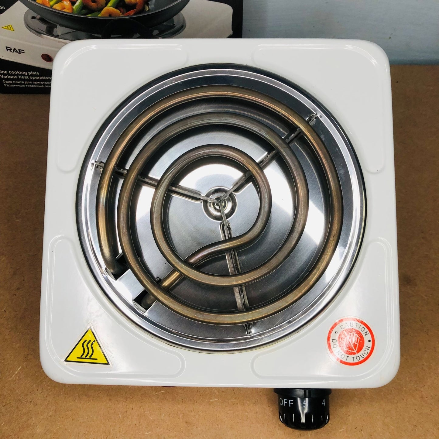 Portable electric stove with spiral heating element on a brown surface