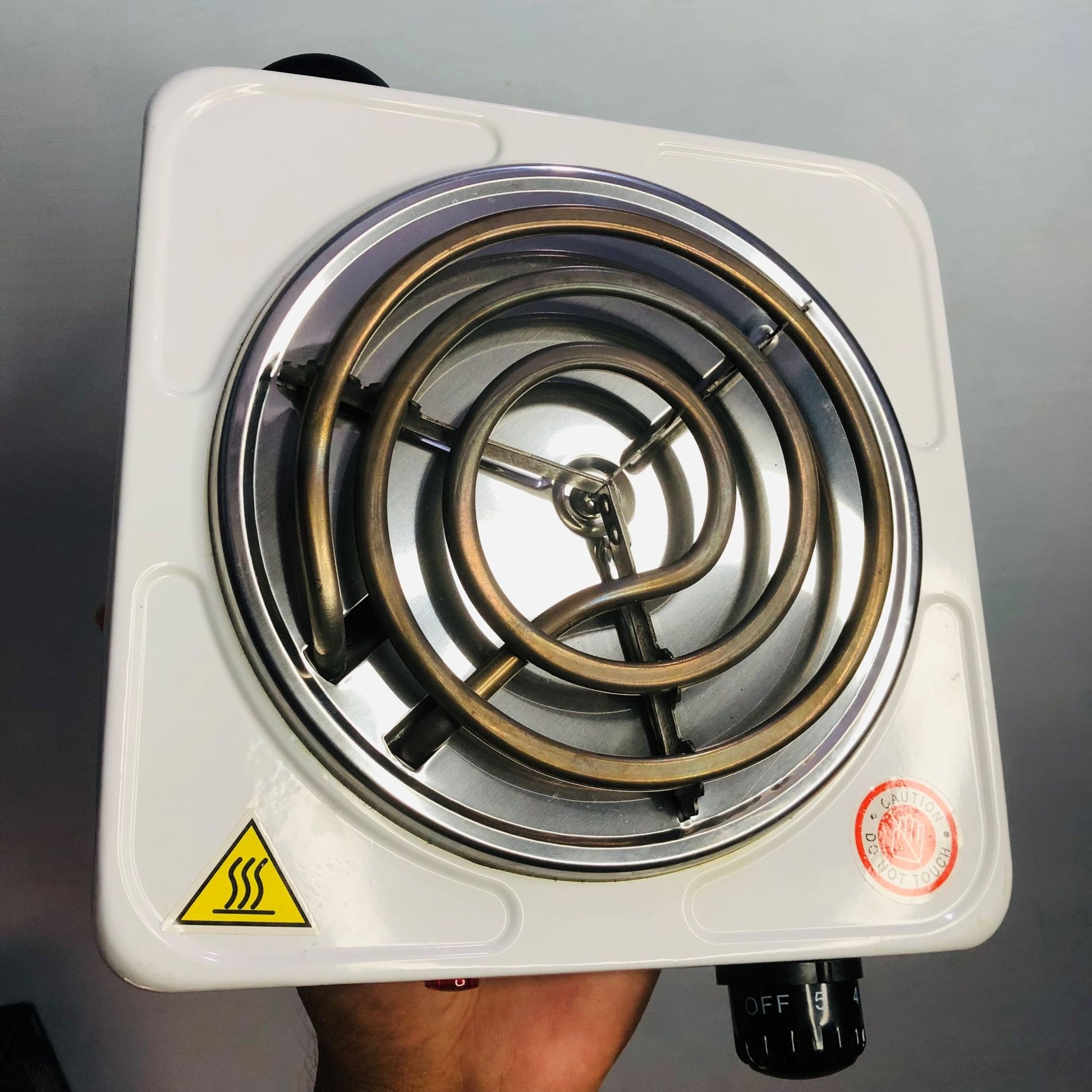 Single burner electric stove with spiral heating element on a gray background